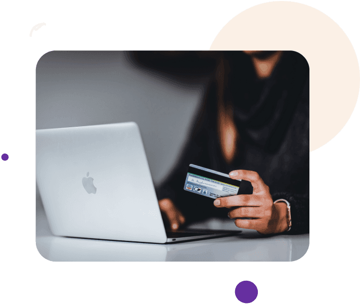 A woman is using a credit card with the laptop.