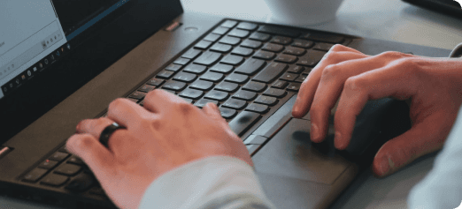 Man's hands working on black laptop