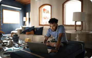 Man with prosthetic leg sitting on couch using laptop