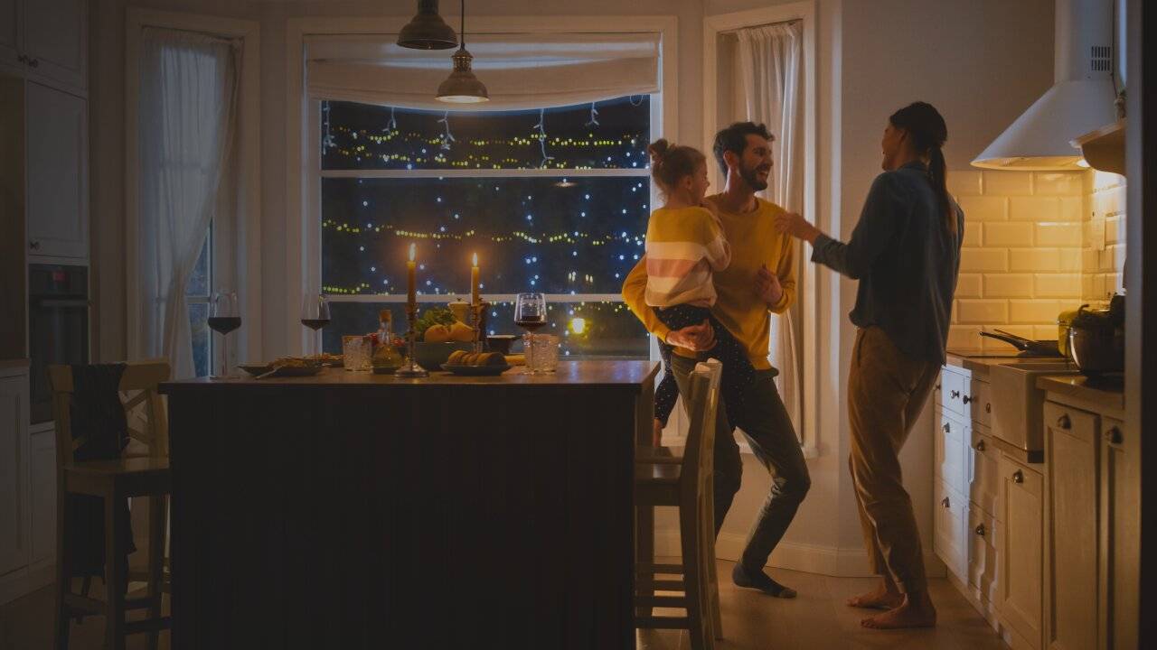 A couple standing with a child in the dining room.