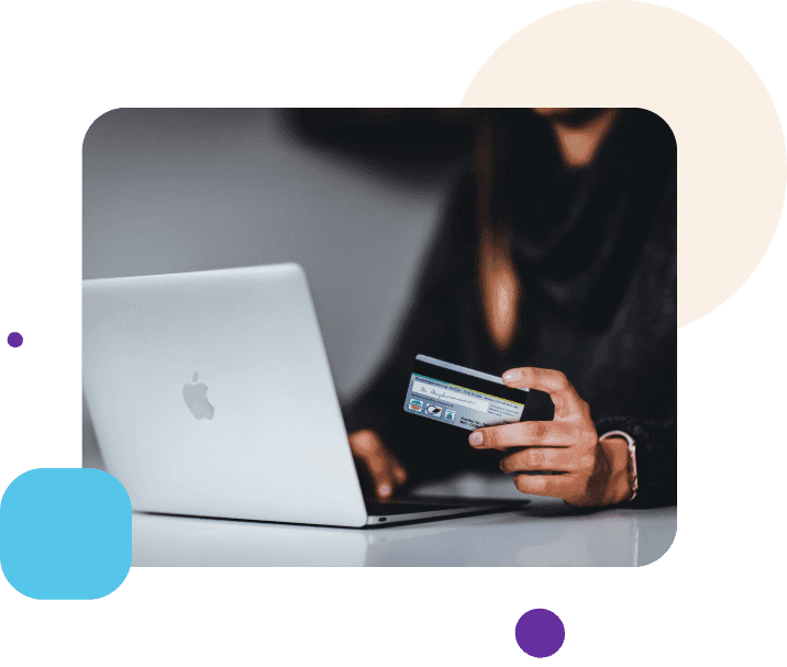 A woman is using a credit card with the laptop.