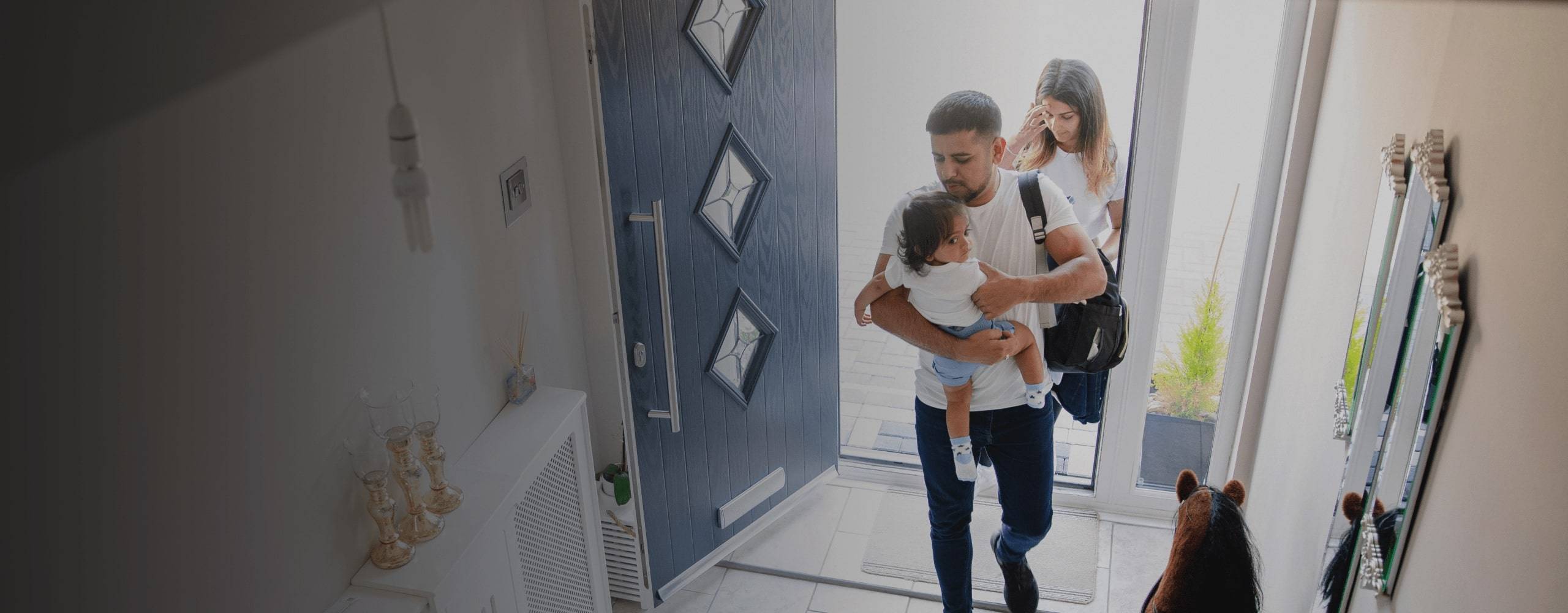 A couple walks through the door with a child.